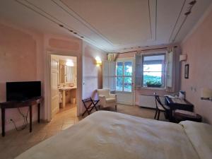 a bedroom with a bed and a desk and a television at Il Melograno Country House in Saturnia