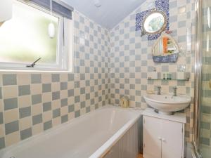ein Badezimmer mit Waschbecken und Badewanne und Waschbecken in der Unterkunft Mackerel Cottage in Budleigh Salterton + 30 Fotos