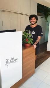 a man standing behind a counter with a potted plant at Che Lagarto Hostel Ipanema in Rio de Janeiro