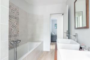 a white bathroom with a tub and a sink at Maison pour 5 personnes - 500m de la plage in Noirmoutier-en-l'lle +14 photos