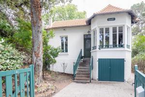 une maison blanche avec une porte et des escaliers verts dans l'établissement Charmante maison pour 5 personnes sur l'Ile de Noirmoutier, à Noirmoutier-en-l'lle