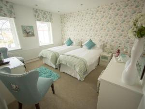 1 Schlafzimmer mit 2 Betten, einem Schreibtisch und einem Stuhl in der Unterkunft Queen Bee & B in Merthyr Tydfil