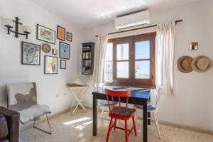 ネルハにあるCapistrano Playaのテーブルと椅子、窓が備わる客室です。