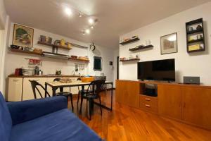 a living room with a blue couch and a table at Living Rencio: vicino al Centro di Bolzano in Bolzano