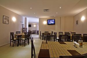 a restaurant with tables and chairs and a tv on the wall at Sunset Complex in Kosharitsa