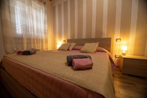 [Castiglion Fiorentino] Chicca sotto la Torre في كاستيجليون فيورنتينو: غرفة نوم بسرير كبير عليها منشفتين