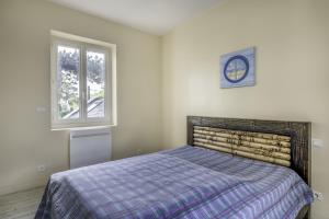 een slaapkamer met een bed en een klok aan de muur bij Villa Les Libellules pour 8 à 9 personnes in La Baule