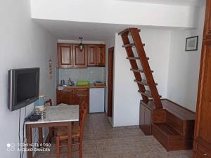 eine Küche mit einem Tisch und eine Treppe in einem Zimmer in der Unterkunft ASVESTOTI MESONETTES BLUE LIGHT ΣΙΕΛ ΜΕΖΟΝΕΤΕs in Pera Gyalos