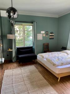 um quarto com uma cama, uma cadeira e uma janela em sleep & go -Meran easy staying em Merano
