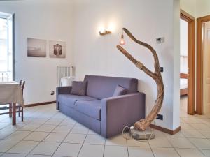 a living room with a blue couch and a branch lamp at Medusa Apartment - Bilocale Centro in Finale Ligure