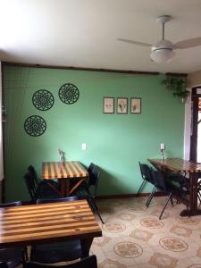 a room with two tables and a green wall at POUSADA LOS AMIGOS CAMPECHE in Florianópolis