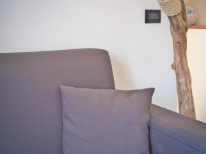 a blue couch with a pillow in a room at Medusa Apartment - Bilocale Centro in Finale Ligure
