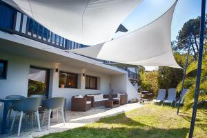 een patio met een tafel en stoelen in het gras bij Appartement loft 1 TARNOS in Tarnos