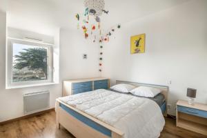 ein Schlafzimmer mit einem Bett und einem Fenster in der Unterkunft Maison pour 8 personnes à Sarzeau - Superbe jardin in Sarzeau