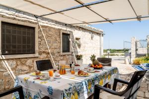 Una mesa con comida y jugo de naranja encima. en Ilice Country House, en Marina di Ragusa