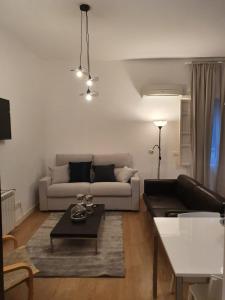 una sala de estar con un sofá y una mesa en Le Petit Palü-Fuencarral, en Madrid