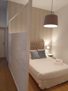 1 dormitorio con cama blanca y pared de metal en Le Petit Palü-Fuencarral, en Madrid