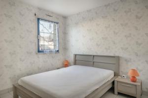 - une chambre avec un lit blanc et une fenêtre dans l'établissement Vacances en famille sur la côte sauvage du Croisic, au Croisic