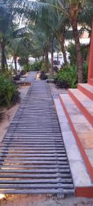 a long walkway with palm trees on a beach at Pousada Lotus in Prea