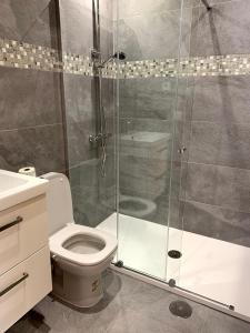 La salle de bains est pourvue de toilettes et d'une douche en verre. dans l'établissement Naranjo 7 - N565 - 2 bathrooms Apartment in Alhama de Murcia Golf Resort, à Alhama de Murcia