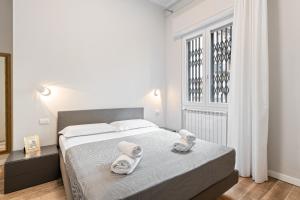 1 dormitorio con 1 cama con toallas en Maragliano Cozy Flat with Balcony, en Florencia