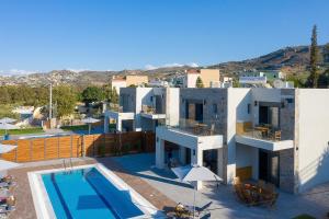 a villa with a swimming pool and a resort at Olive and Sea Villas in Agia Pelagia