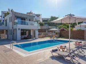 eine Villa mit einem Pool und einem Haus in der Unterkunft Olive and Sea Villas in Agia Pelagia