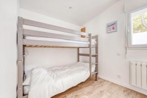 a bedroom with two bunk beds and a window at Séjour détente à Bretignolles-sur-Mer pour 5 personnes in Brétignolles-sur-Mer