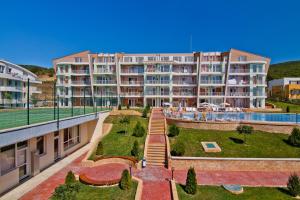 a large apartment building with a garden in front of it at Sunset Complex in Kosharitsa