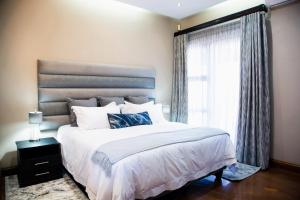 a bedroom with a large bed and a window at Schimper View Boutique Guest House in Louis Trichardt