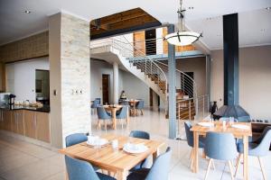 uma sala de jantar com mesas e cadeiras e uma escadaria em Schimper View Boutique Guest House em Louis Trichardt