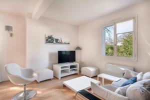 sala de estar con sofá y TV en Charmante maison pour 11 personnes a Sarzeau, en Sarzeau