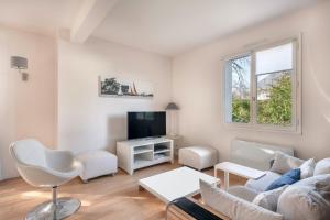 a living room with a couch and a tv at Charmante maison pour 11 personnes à Sarzeau in Sarzeau