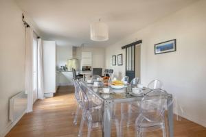 comedor con mesa de cristal y sillas en Charmante maison pour 11 personnes a Sarzeau, en Sarzeau