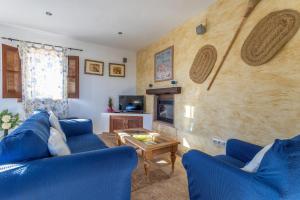 a living room with two blue couches and a table at Fuente luz cottage in Frigiliana