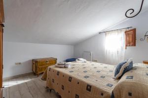 a bedroom with two beds and a window at Fuente luz cottage in Frigiliana +18 photos