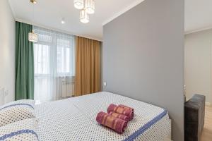 a bedroom with a bed with a blue and white table at Золотой квадрат Астаны in Astana