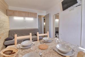 a living room with a table with plates and glasses at Appartement confortable et lumineux a Genos in Génos