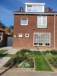 una casa de ladrillo con un jardín delante de ella en Guesthouse de Hoogkamp en Arnhem