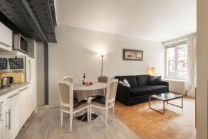 ein Wohnzimmer mit einem Tisch und einem Sofa in der Unterkunft Apart of Paris - Chatelet - Rue de Rivoli in Paris