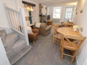 Honey Pot Cottage في لانكستر: غرفة معيشة بها درج وطاولة وكراسي