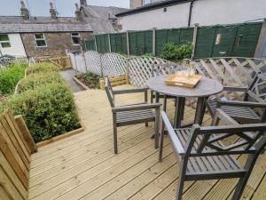 un patio con mesa y sillas en una terraza en Honey Pot Cottage en Lancaster