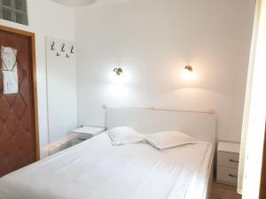 ein Schlafzimmer mit einem weißen Bett und zwei Kissen in der Unterkunft Pensiunea Confort in Suceava