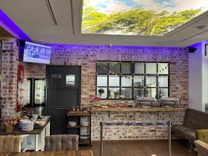 a kitchen with a brick wall and purple lighting at Weyotel in Weyhe