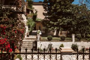 a house with stairs and a fence with red flowers at Villa Butterfly - Heated Pool, Jacuzzi, Sauna, Gym in Corfu Town