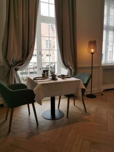 een tafel en stoelen in een kamer met een raam bij Molenmeers Boutique Guesthouses in Brugge