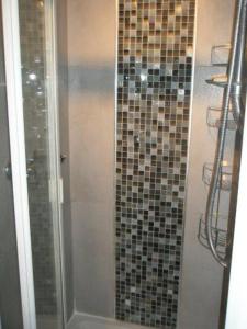 a bathroom with a shower with mosaic tiles on the wall at Kew Gardens National Archives Forest Road in London