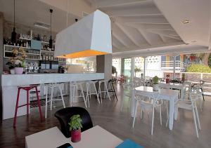 a restaurant with white tables and chairs and a bar at Nelly's Apartments in Tolo