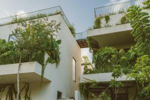 an apartment building with plants on the balconies at Jashita Tulum Luxury Villas in Tulum