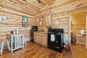 a kitchen with wooden walls and a stove in a cabin at HR Cabin 3- The Little Bear Cabin in Fredericksburg
